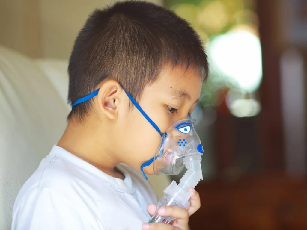 Child receiving nebuliser treatment for asthma symptoms